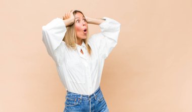 Genç ve güzel bir kadın, ağzı açık, korkunç ve şok olmuş görünüyor, korkunç bir hata yüzünden, el ele tutuşuyor.