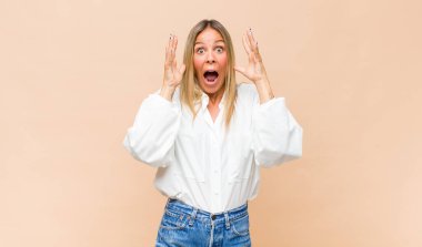 Genç ve güzel bir kadın ellerini havaya kaldırarak bağırıyor. Öfkeli, sinirli, stresli ve üzgün.