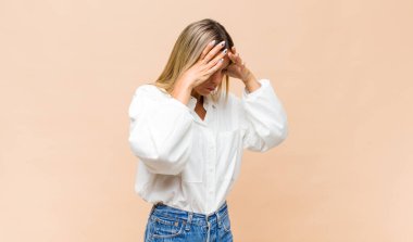 Genç ve güzel bir kadın üzgün, hayal kırıklığına uğramış bir bakışla gözlerini kapatıyor, ağlıyor, yan gözle bakıyor.