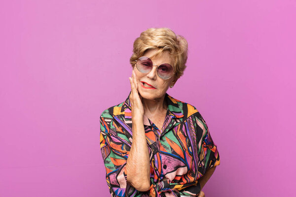 пожилая красивая женщина держит щеку и страдает от боли в зубах, чувствует себя больным, несчастным и несчастным, ищет дантиста