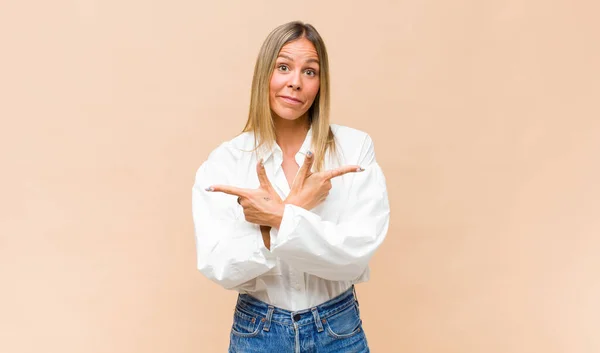 Jovem Bonita Mulher Olhando Confuso Confuso Inseguro Apontando Direções Opostas — Fotografia de Stock