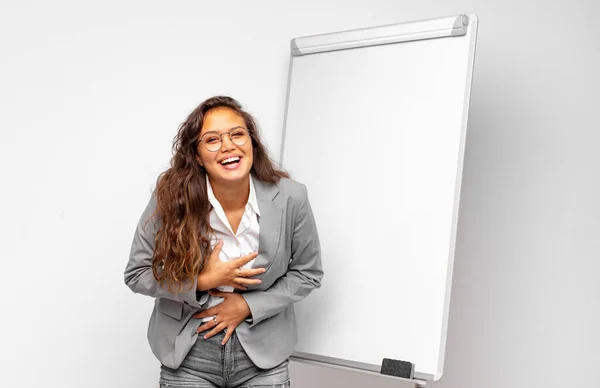 young businesswoman laughing out loud at some hilarious joke, feeling happy and cheerful, having fun