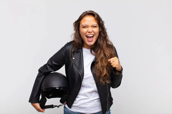 오토바이를 다니는 여자가 공격적으로 외치거나 주먹으로 성공을 축하하는 — 스톡 사진