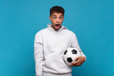young man looking very shocked or surprised, staring with open mouth saying wow. soccer concept