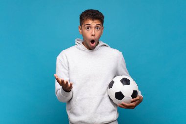 young man open-mouthed and amazed, shocked and astonished with an unbelievable surprise. soccer concept