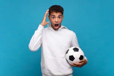 young man screaming with hands up in the air, feeling furious, frustrated, stressed and upset. soccer concept