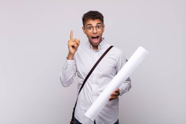 Genç mimar bir fikri fark ettikten sonra mutlu ve heyecanlı bir dahi gibi hissediyor. Neşeli bir şekilde parmağını kaldırıyor.!