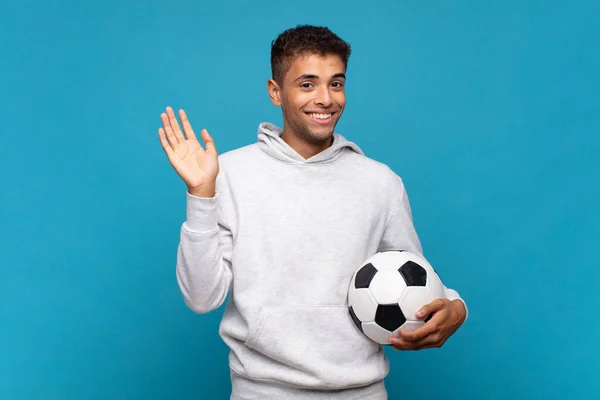 Young Man Smiling Happily Cheerfully Waving Hand Welcoming Greeting You — Stok fotoğraf