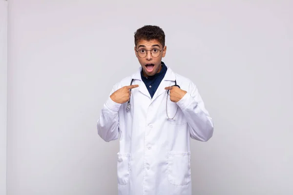 Young Physician Man Feeling Happy Surprised Proud Pointing Self Excited — Φωτογραφία Αρχείου