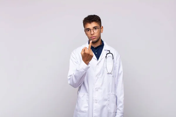 若い医者の男は怒り いらいらし 反抗的で攻撃的で 中指をひっくり返して 反撃して — ストック写真