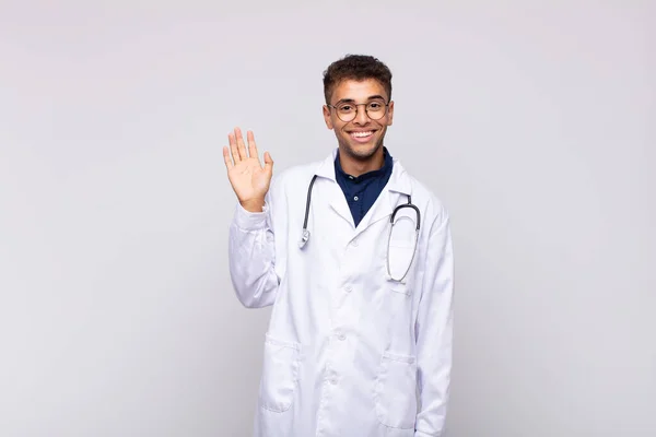 Young Physician Man Smiling Happily Cheerfully Waving Hand Welcoming Greeting — Stock Photo, Image