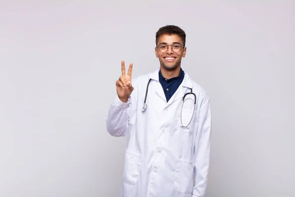 Genç Doktor Gülümsüyor Arkadaş Canlısı Görünüyor Iki Numarayı Gösteriyor Elleri — Stok fotoğraf