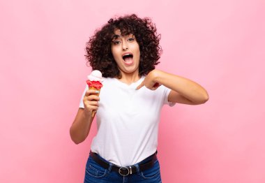 Dondurmalı genç bir kadın mutlu, şaşkın ve gururlu, heyecanlı, şaşkın bakışlarla kendini işaret ediyor.