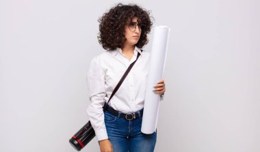 Genç mimar kadın üzgün, üzgün ya da kızgın ve olumsuz bir tavır takınıyor, anlaşmazlıkla kaşlarını çatıyor.