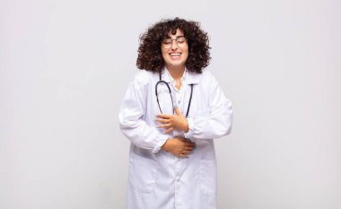 Genç kadın doktor komik bir şakaya yüksek sesle gülüyor, mutlu ve neşeli hissediyor, eğleniyor.