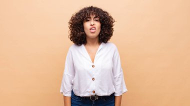 Woman feeling puzzled and confused, with a dumb, stunned expression looking at something unexpected