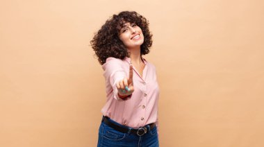 Gururla gülümseyen ve kendinden emin bir şekilde bir numaralı pozu veren bir kadın kendini lider gibi hisseder.