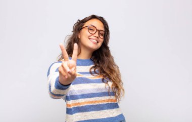 Gülümseyen ve mutlu görünen kız, kaygısız ve pozitif, zafer ya da huzur simgesi.