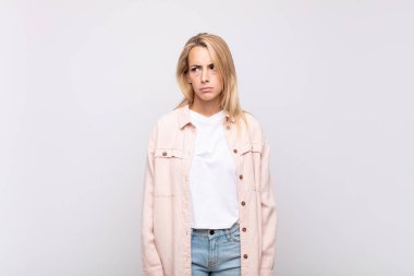 Kadın üzgün, üzgün ya da kızgın ve olumsuz bir tavır takınıyor, anlaşmazlık içinde kaşlarını çatıyor.