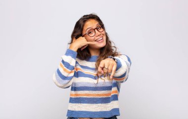 Neşeli bir şekilde gülümseyen ve kamerayı işaret eden bir kız daha sonra seni arayıp, telefonla konuşan bir jest yapar.