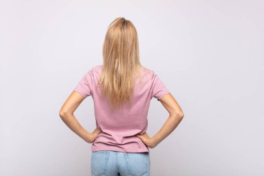 Kadın kafası karışık ya da dolu ya da şüphe ve soru dolu, merak ediyor, elleri kalçasında, dikiz aynasından