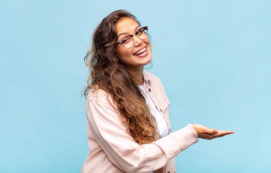 Neşeli bir şekilde gülümseyen, mutlu hisseden ve fotokopi alanında bir konsept gösteren bir kız.