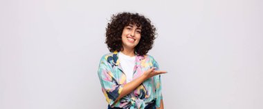 Neşeli bir şekilde gülümseyen, mutlu hisseden ve fotokopi alanında avucunun içinde bir konsept gösteren bir kadın.