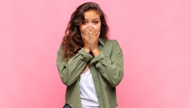 Kız endişeli, üzgün ve korkmuş, elleriyle ağzını kapatıyor, endişeli ve berbat görünüyor.
