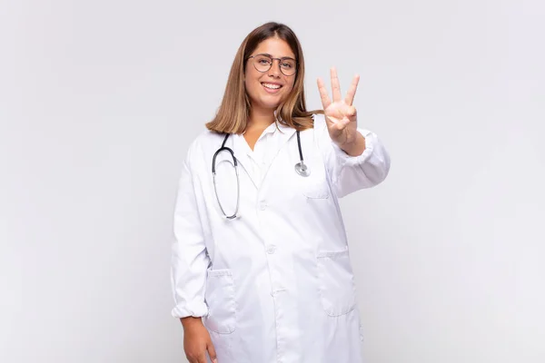 Mladá Žena Lékař Usmívá Vypadá Přátelsky Ukazuje Číslo Tři Nebo — Stock fotografie