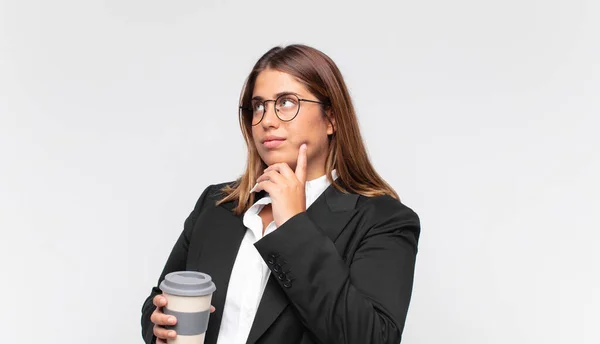 Jonge Zakenvrouw Met Een Koffie Glimlachend Gelukkig Dagdromend Twijfelend Kijken — Stockfoto