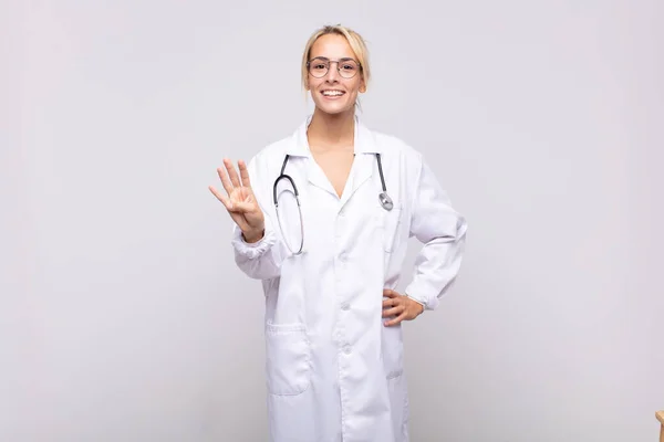 Mujer Joven Médico Sonriendo Buscando Amigable Mostrando Número Cuatro Cuarto —  Fotos de Stock