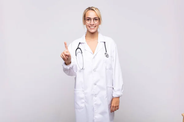 Ung Kvinna Läkare Ler Och Ser Vänlig Visar Nummer Ett — Stockfoto