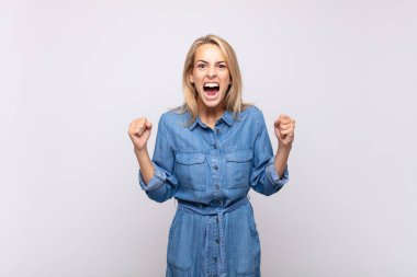 Öfkeli bir ifadeyle ya da yumruklarıyla başarıyı kutlayan bir kadınla.