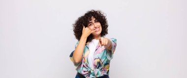 Neşeli bir şekilde gülümseyen ve kamerayı işaret eden bir kadın seni daha sonra arar, telefonda konuşur.