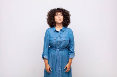 Kadın kendini şaşkın ve şüpheli hissediyor, merak ediyor ya da karar vermeye çalışıyor.