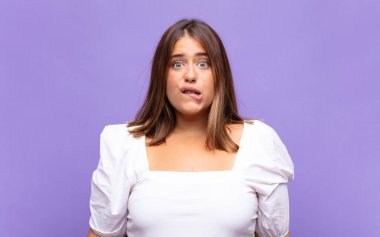 Genç sarışın kadın şaşkın ve şaşkın görünüyor. Sinirli bir hareketle dudağını ısırıyor. Sorunun cevabını bilmiyor.