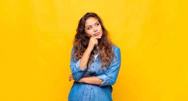 Kız düşünceli, meraklı ya da hayal kuruyor, hayal kuruyor ve boşluğu doldurmaya çalışıyor.