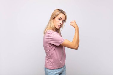 Kadın kendini mutlu, tatmin olmuş ve güçlü hissediyor, kaslı ve formda, spor salonundan sonra güçlü görünüyor.