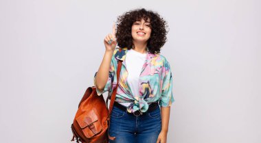 Neşeli ve mutlu bir şekilde gülümseyen bir kadın, tek eliyle boşluğu dolduruyor.