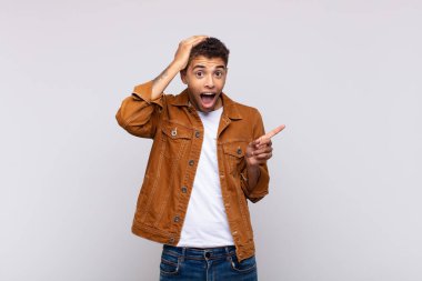  Gülüyor, mutlu, pozitif ve şaşırmış görünüyor. Yan fotokopi alanını işaret eden harika bir fikri fark ediyor.