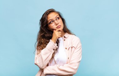 Kadın düşünceli, meraklı ya da hayal kuruyor, hayal kuruyor ve uzayı taklit etmeye çalışıyor.