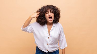 Kadın mutsuz ve stresli görünüyor, intihar jesti elle silah işareti yapıyor, kafasını işaret ediyor.