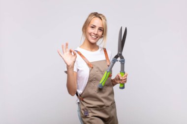 Budama makası olan güzel, sarışın bir kadın.