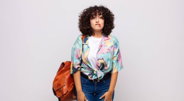 Şaşırmış ve kafası karışmış bir kadın, gergin bir hareketle dudağını ısırıyor, sorunun cevabını bilmiyor.