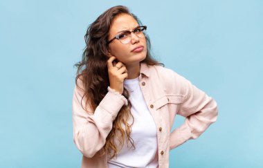 Stresli, hayal kırıklığına uğramış ve yorgun hisseden bir kadın endişeli ve sorunlu bir bakışla boynunu ovalıyor.