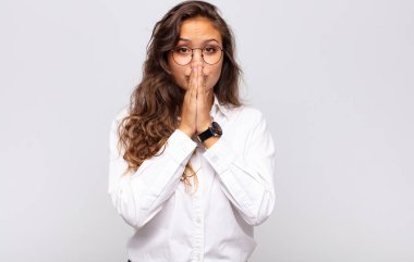 Kadın endişeli, üzgün ve korkmuş, elleriyle ağzını kapatıyor, endişeli ve berbat görünüyor.