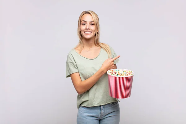 Mujer Joven Con Cubo Granos Pop Mirando Emocionado Sorprendido Apuntando —  Fotos de Stock