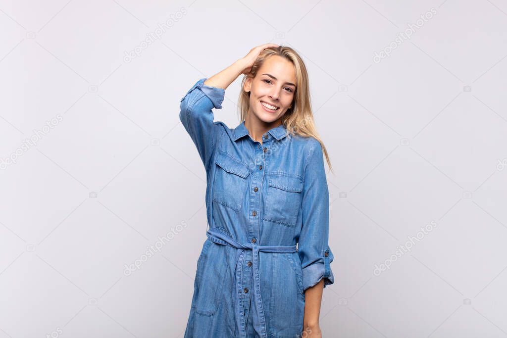 Woman smiling cheerfully and casually, taking hand to head with a positive, happy and confident look