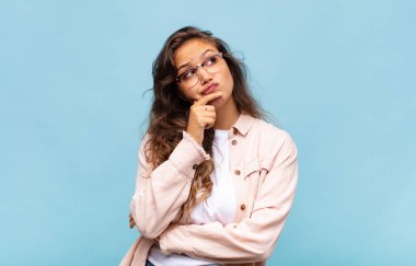 Kadın düşünüyor, kuşkulu ve şaşkın hissediyor, farklı seçeneklerle, hangi kararı vereceğini merak ediyor.