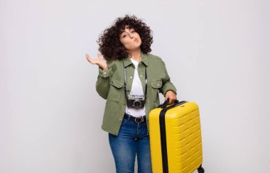 Genç Arap kadın şaşkın ve şaşkın hissediyor, şüpheci, farklı seçenekleri tartıyor ya da seçiyor komik ifade seyahat konseptiyle